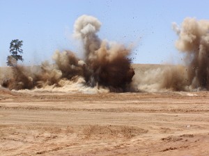 A large explosion in the middle of an open field.