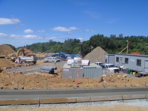 A construction site with many vehicles parked on the side of it.