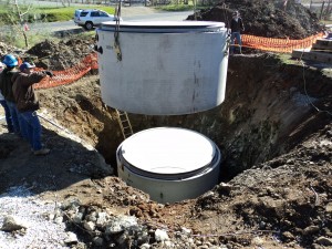 A white bucket is in the ground and some dirt