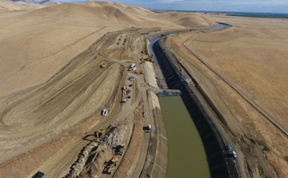 Aerial view of canal construction in desert.