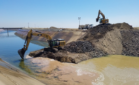 Excavators working on riverbank construction project.