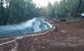 Concrete slide construction in wooded area.