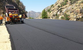 Road construction with workers and paving machine.